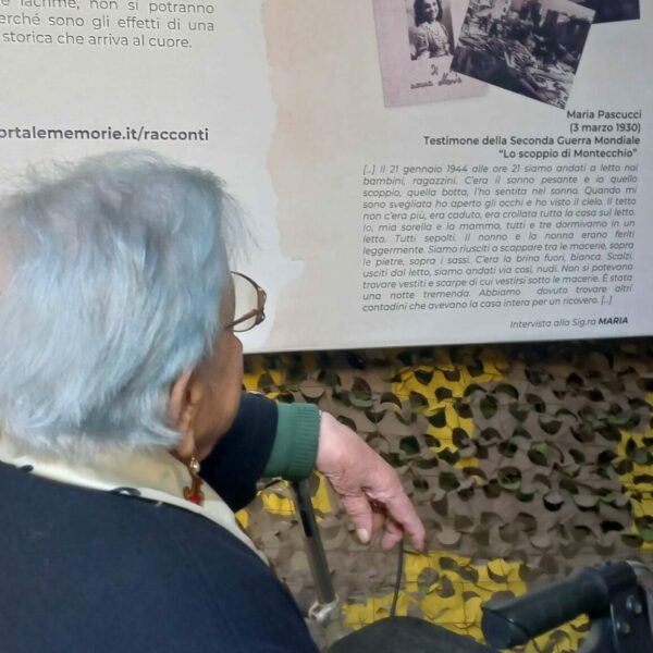 2025-05-24 Inaugurazione 3 edizione mostra Portale delle Memorie presso il cortile di Palazzo Gradari-sig.ra Maria legge il pannello con il suo racconto